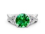 Round Cut Emerald Solitaire Ring in White gold with Interwoven Pavé Band and Prong Setting