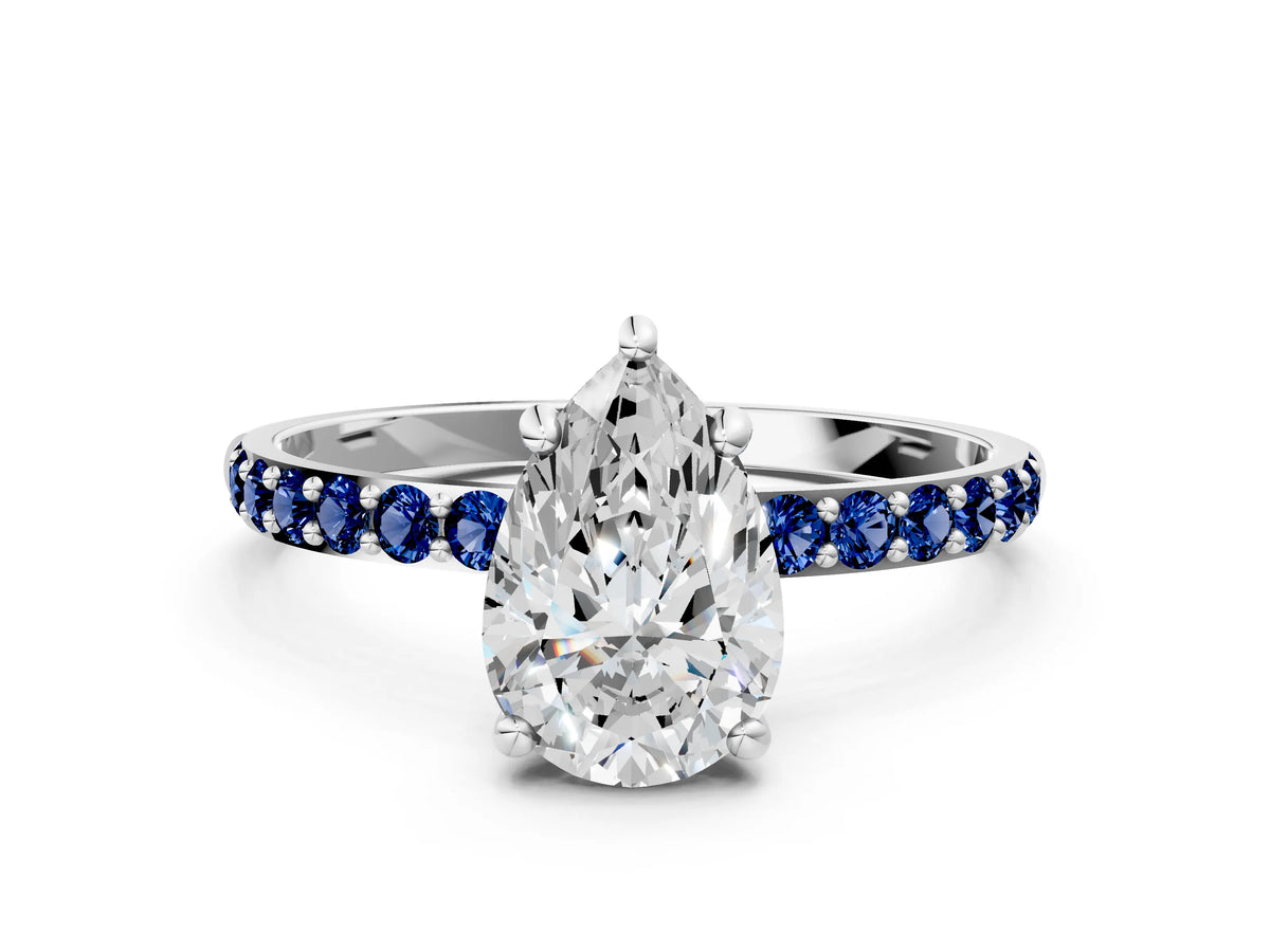 White gold Pear Cut Diamond Solitaire Ring with Round Blue Sapphire Pavé Band and Prong Setting