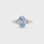 Yellow gold Fancy Blue Oval Cut Three Stone Diamond Engagement Ring with Tapered Baguette and Round Side Stones