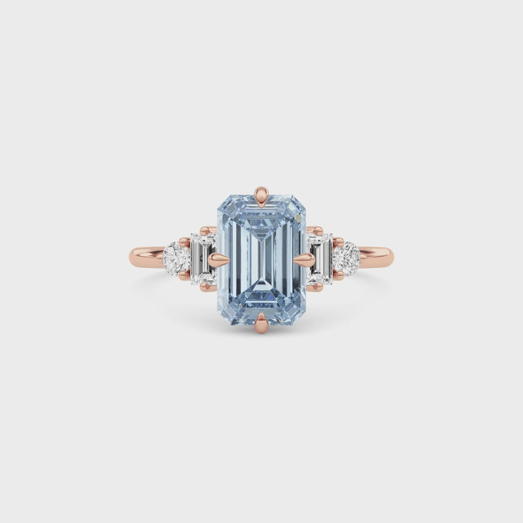 Rose gold Fancy Blue Emerald Cut Three Stone Diamond Engagement Ring with Tapered Baguette and Round Side Stones