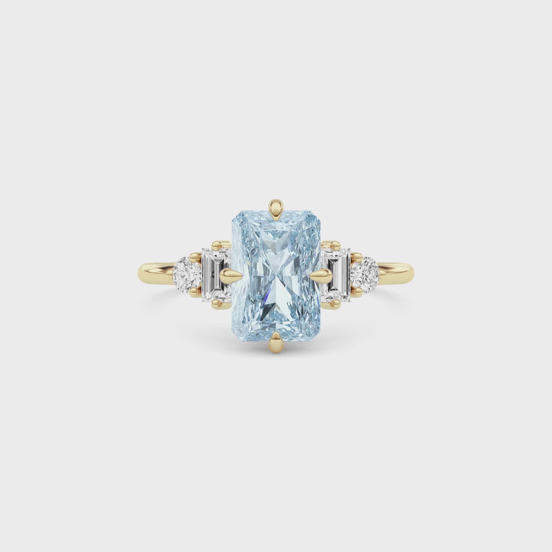 Yellow gold Fancy Blue Radiant Cut Three Stone Diamond Engagement Ring with Tapered Baguette and Round Side Stones