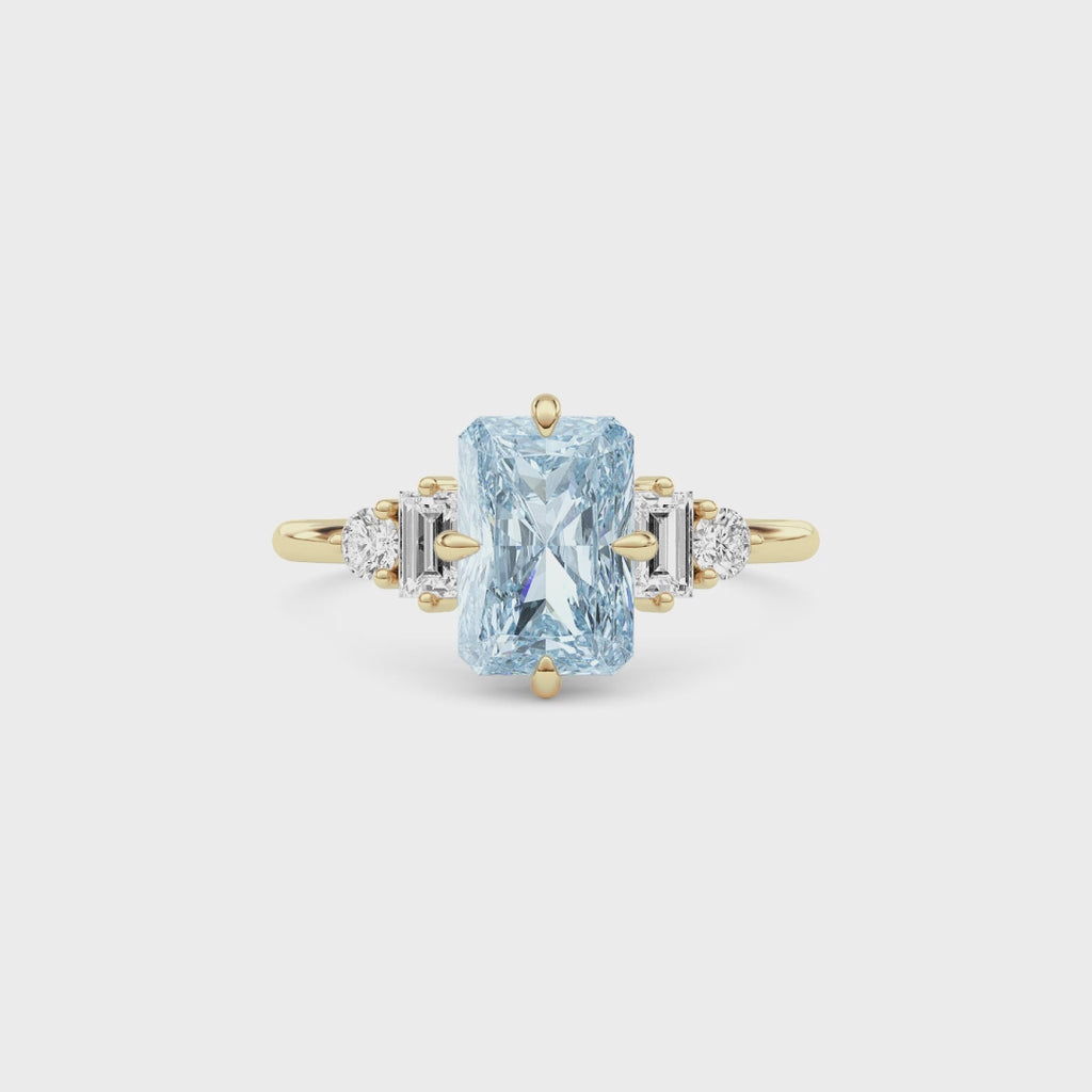 Yellow gold Fancy Blue Radiant Cut Three Stone Diamond Engagement Ring with Tapered Baguette and Round Side Stones
