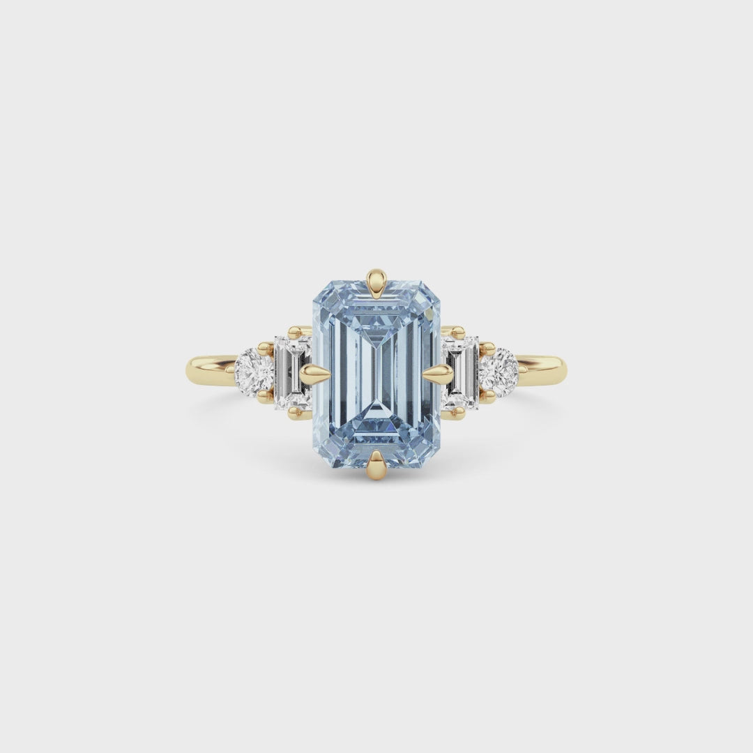 Yellow gold Fancy Blue Emerald Cut Three Stone Diamond Engagement Ring with Tapered Baguette and Round Side Stones