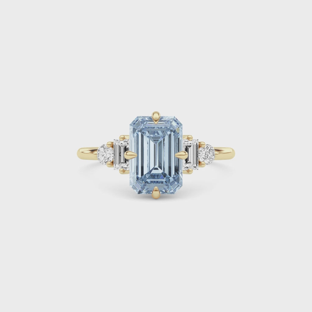 Yellow gold Fancy Blue Emerald Cut Three Stone Diamond Engagement Ring with Tapered Baguette and Round Side Stones